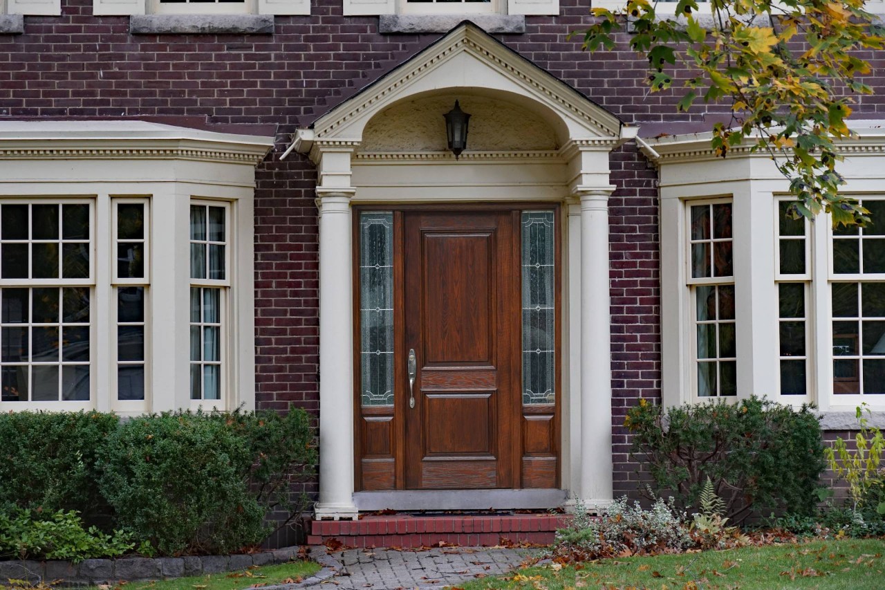 An elegant front door with sidelights that could benefit from window treatments at The Shady Lady Interiors near Oklahoma City, OK